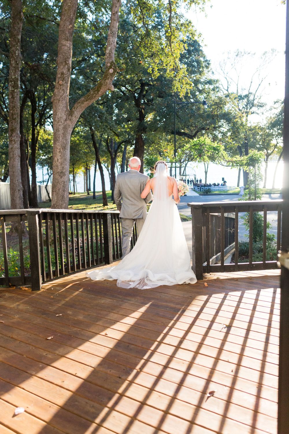 Couple shares private moment on wooden deck overlooking waterfront.