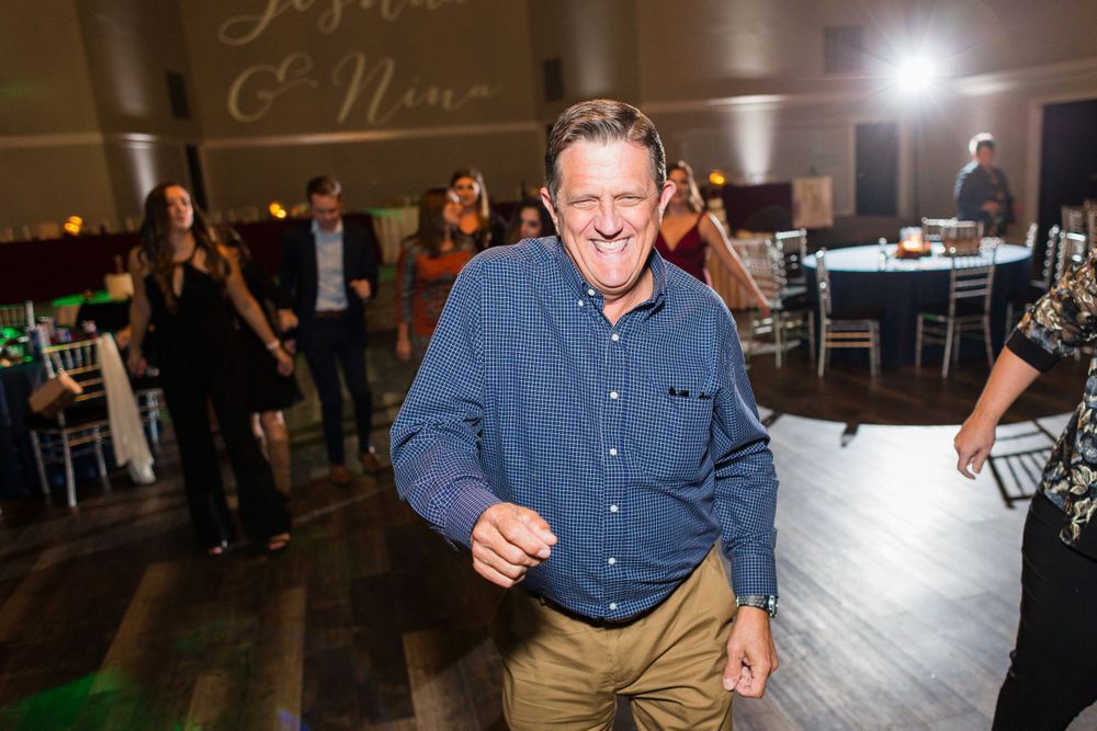 A guest enjoying themselves on the dance floor at a wedding reception.