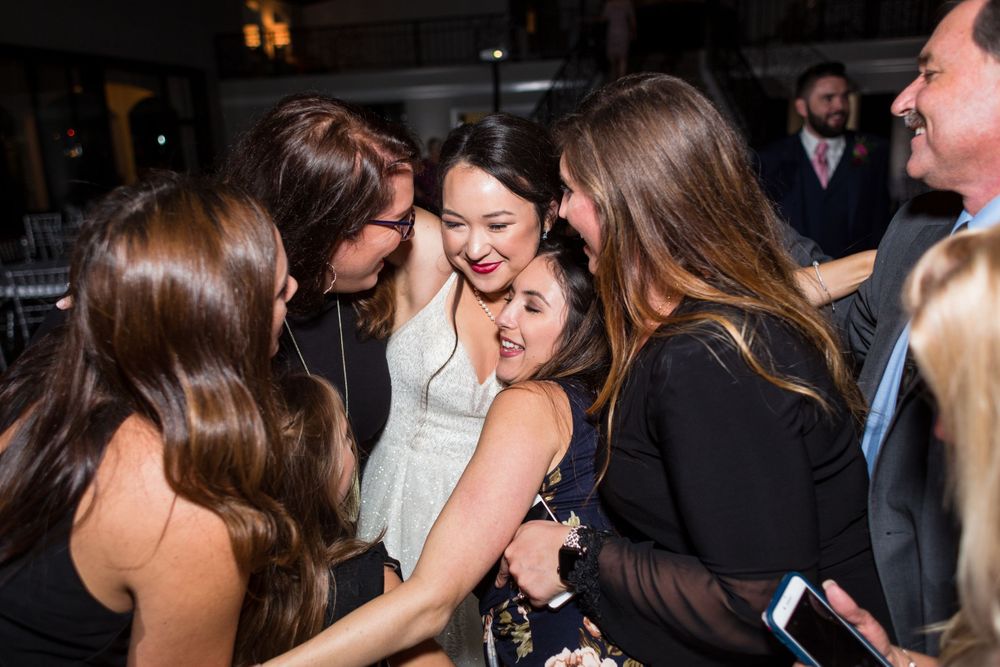 A group of wedding guests sharing a joyful moment on the dance floor.