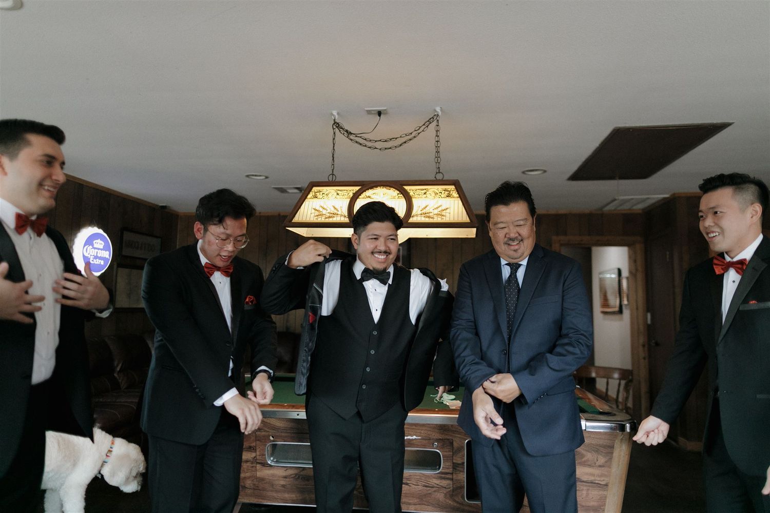 A group in formal attire gathered under a vintage chandelier.