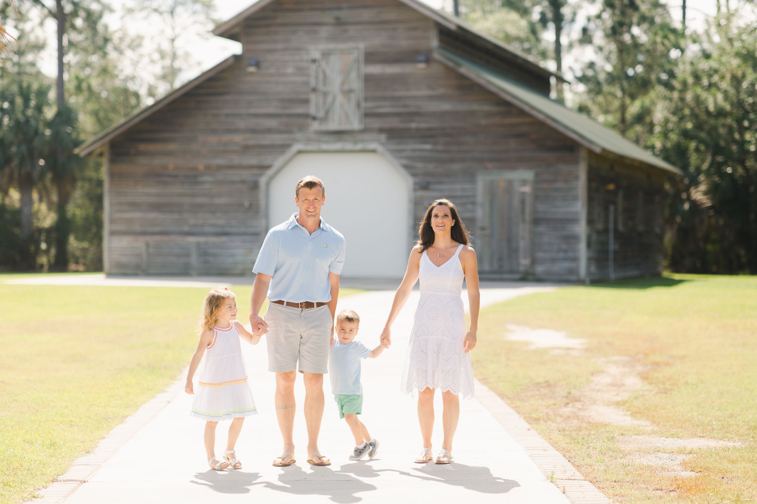 Family stands together for photograph on path in front of rustic wooden building in Beaufort, South Carolina.
