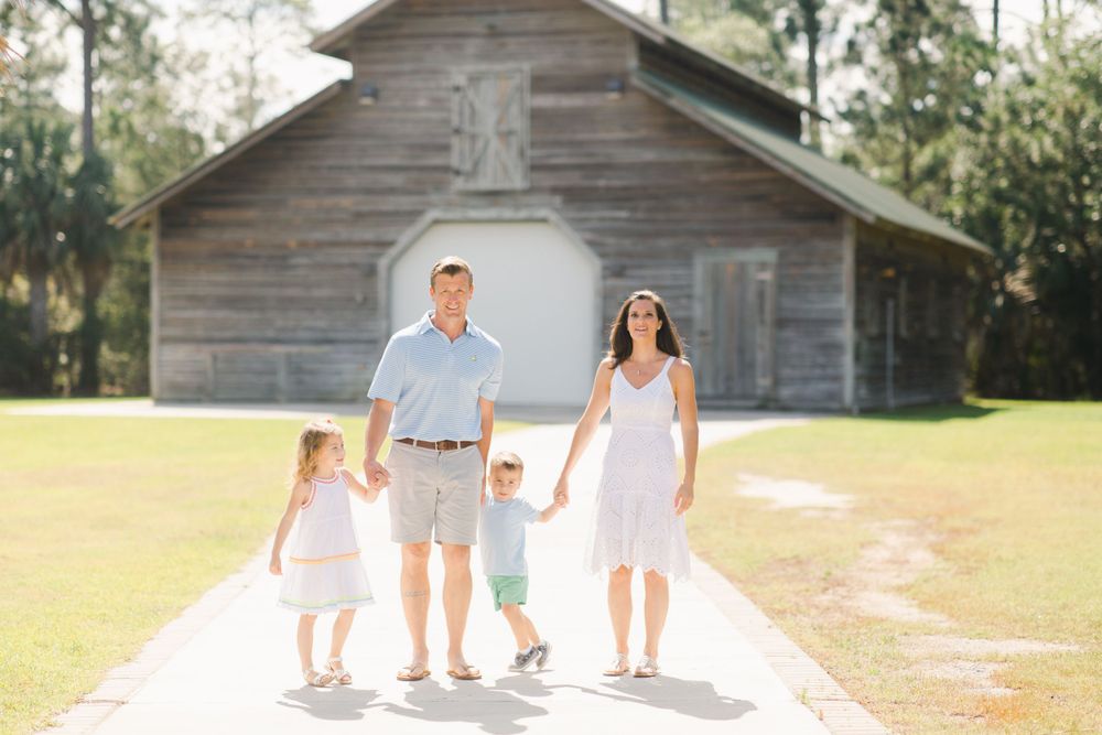Family stands together for photograph on path in front of rustic wooden building in Beaufort, South Carolina.