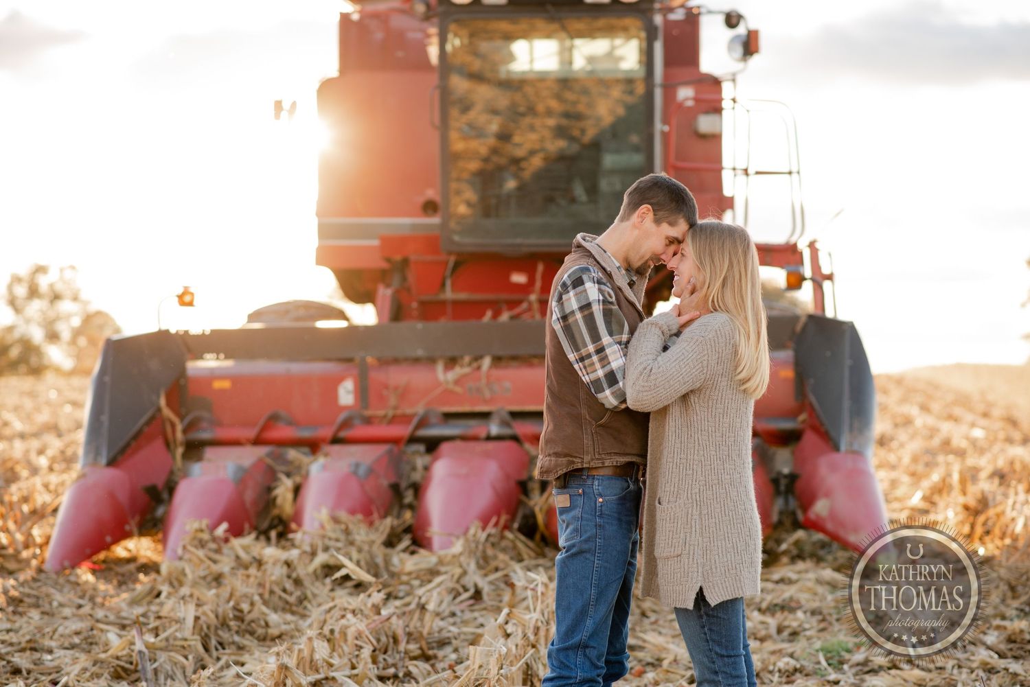 Romantic moment between couple in front of combine harvester at sunset.