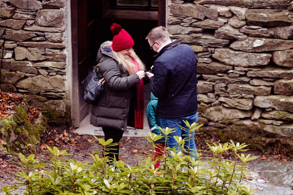 Winter-clad visitors examining the entrance of an old stone structure.