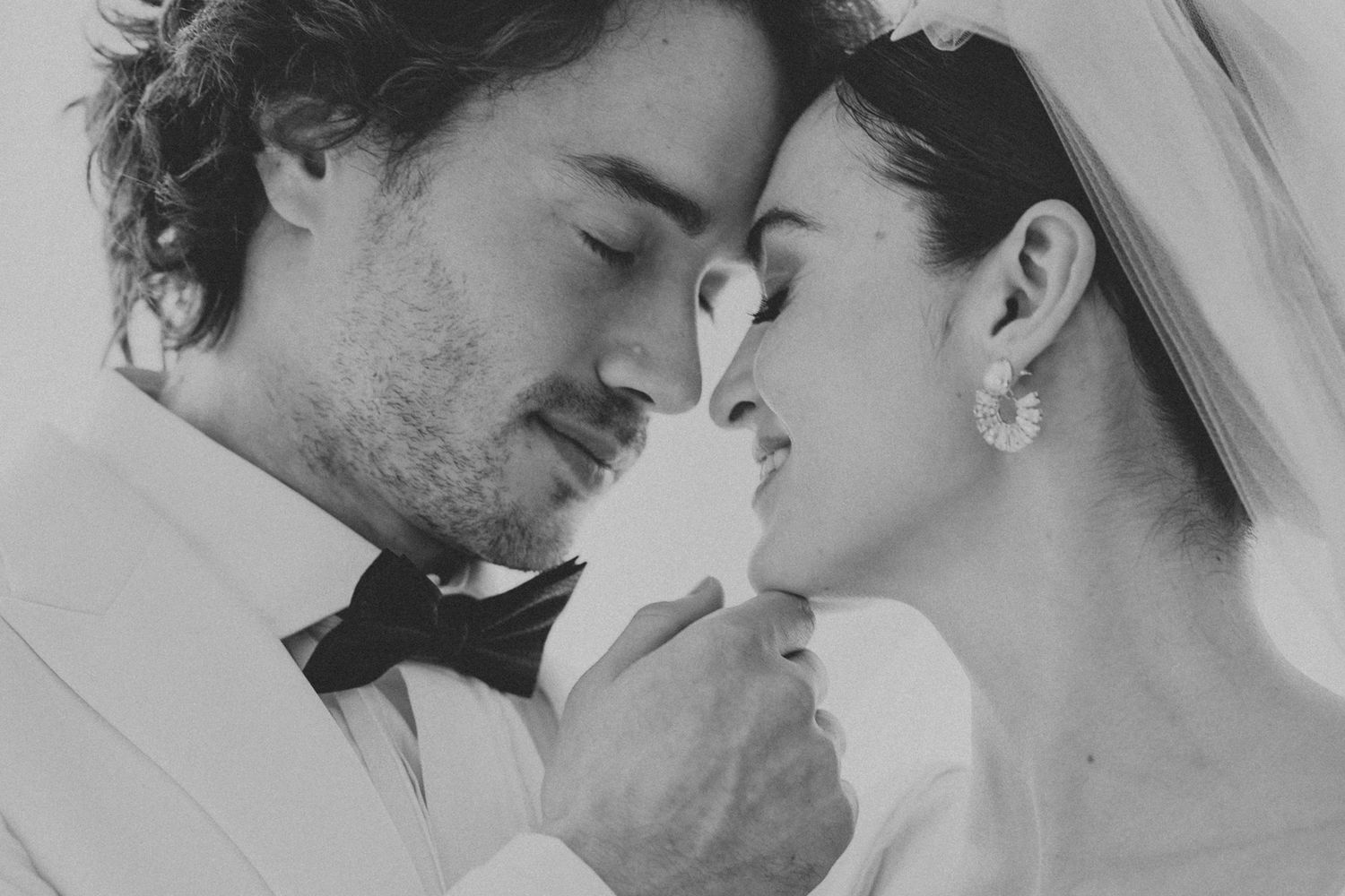 Four black and white photos show intimate romantic moments between a couple embracing and kissing.