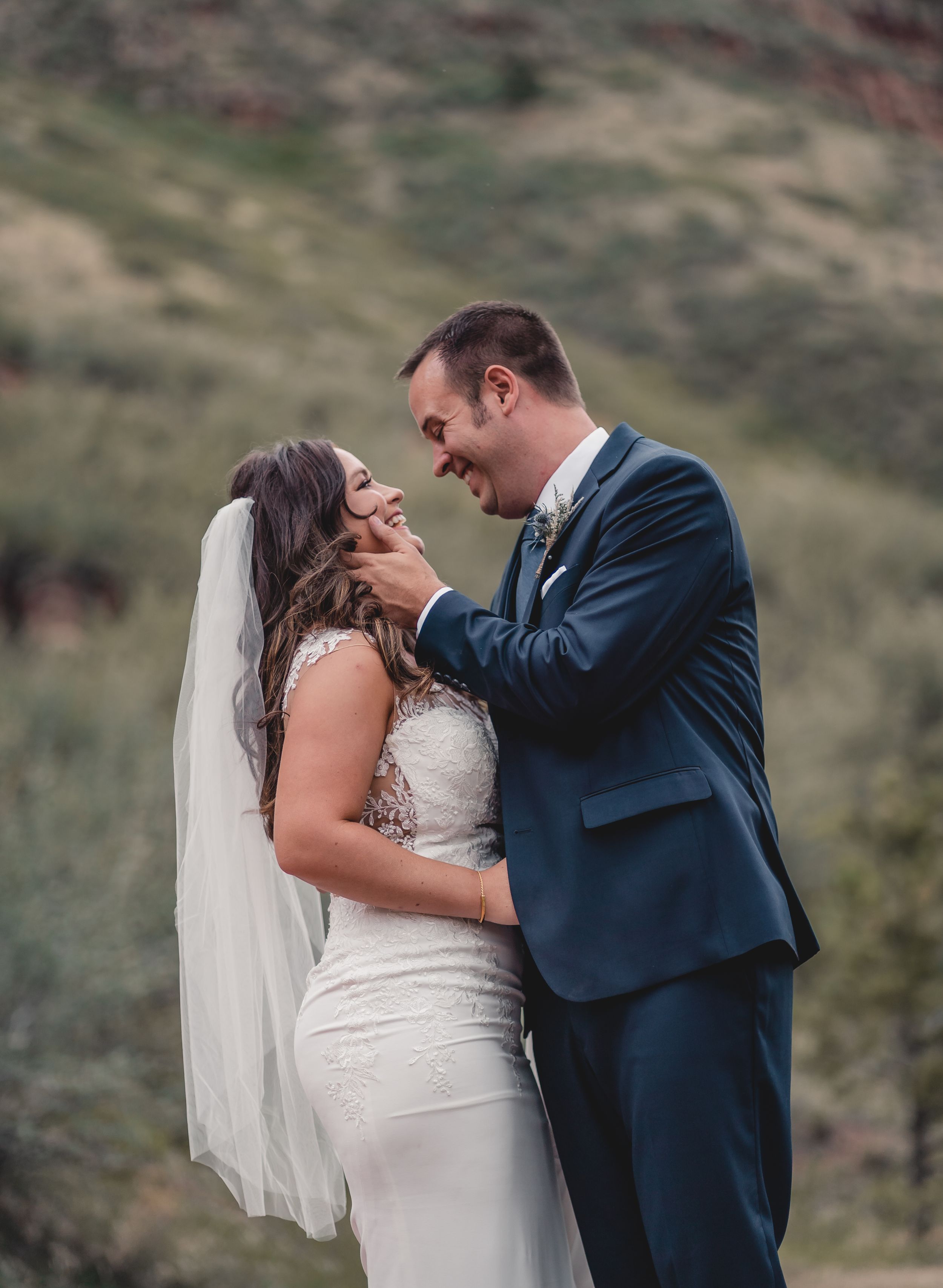 Joyful wedding moment captured against scenic mountain backdrop.