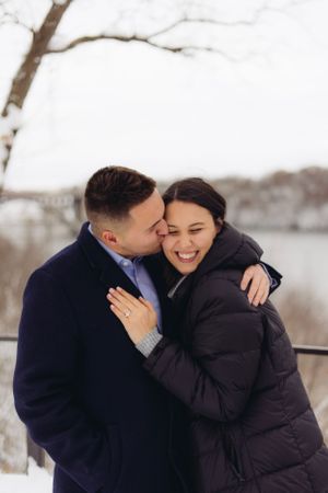A tender winter moment between a couple sharing an intimate embrace in the snow.