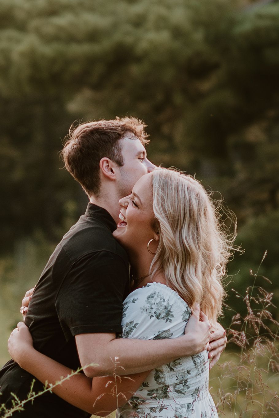 Intimate sunset portrait of couple embracing in golden hour light.