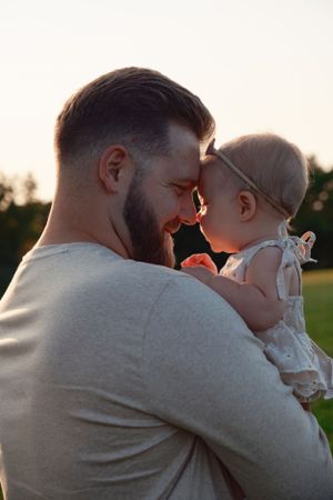 close up of a man touching forehead with his baby