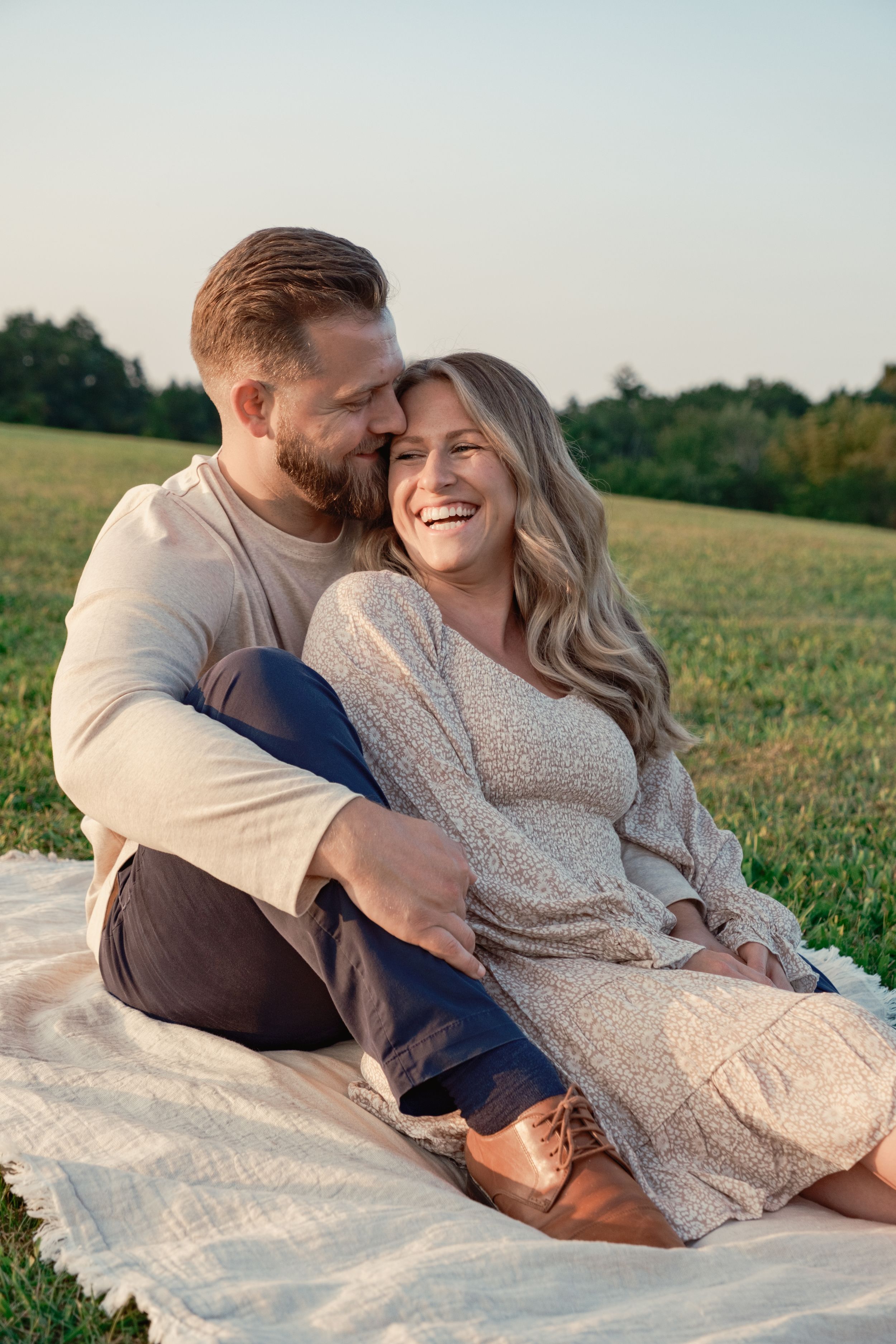 Blonde woman sitting back snuggled up to husband laughing