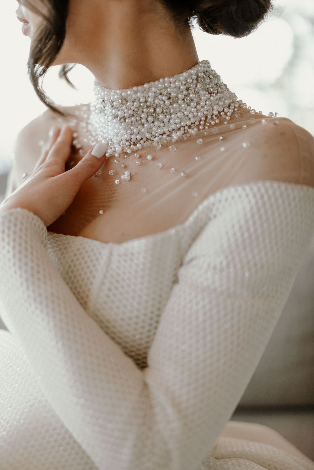 Close up of intricate pearl beaded high neck wedding dress collar detail.