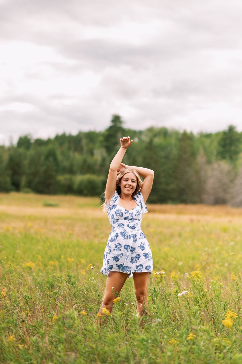Senior girl poses in field in Orr, Minnesota.