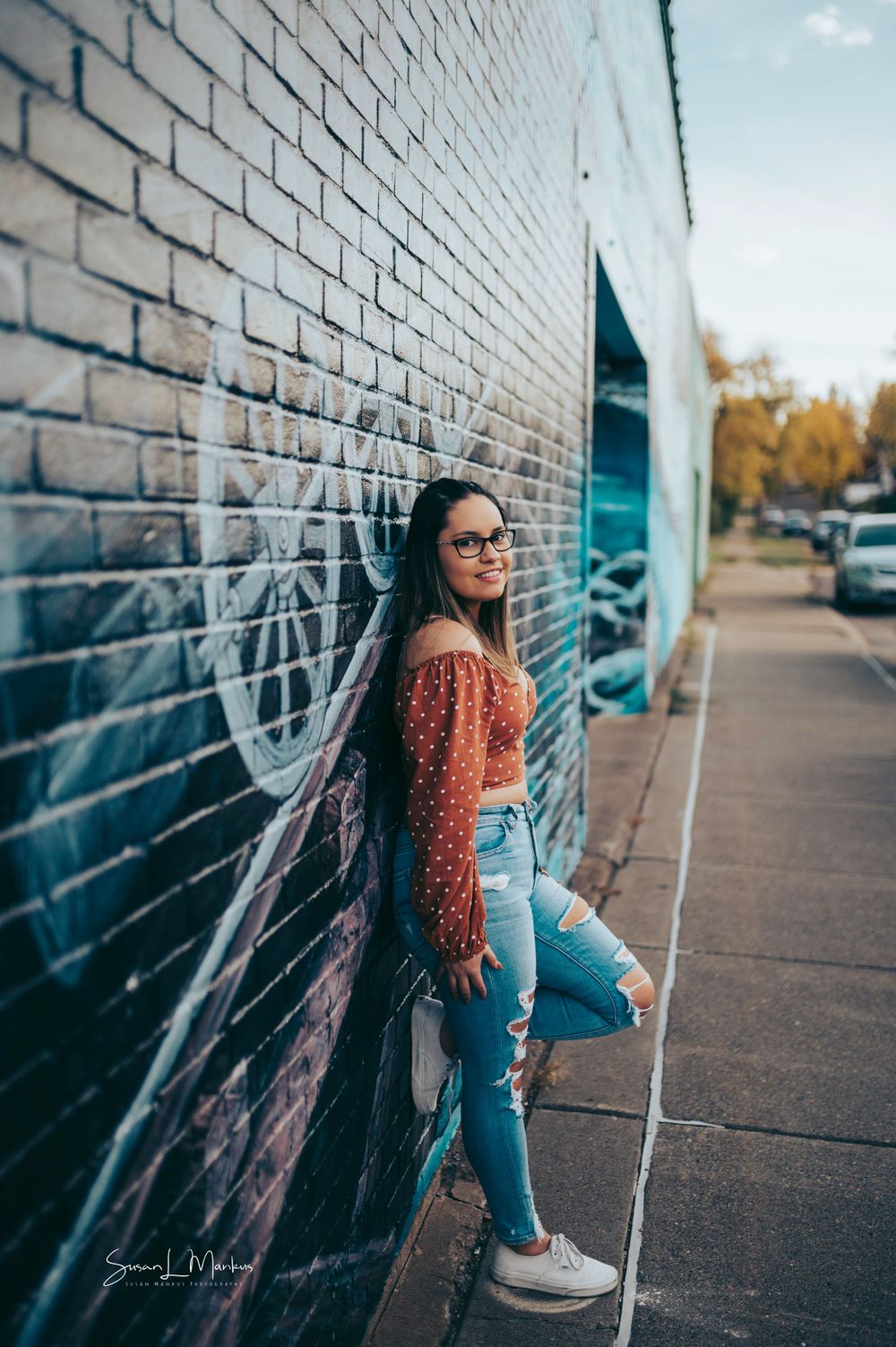 Posing by graffiti wall in Cloquet, Minnesota for senior photoshoot.
