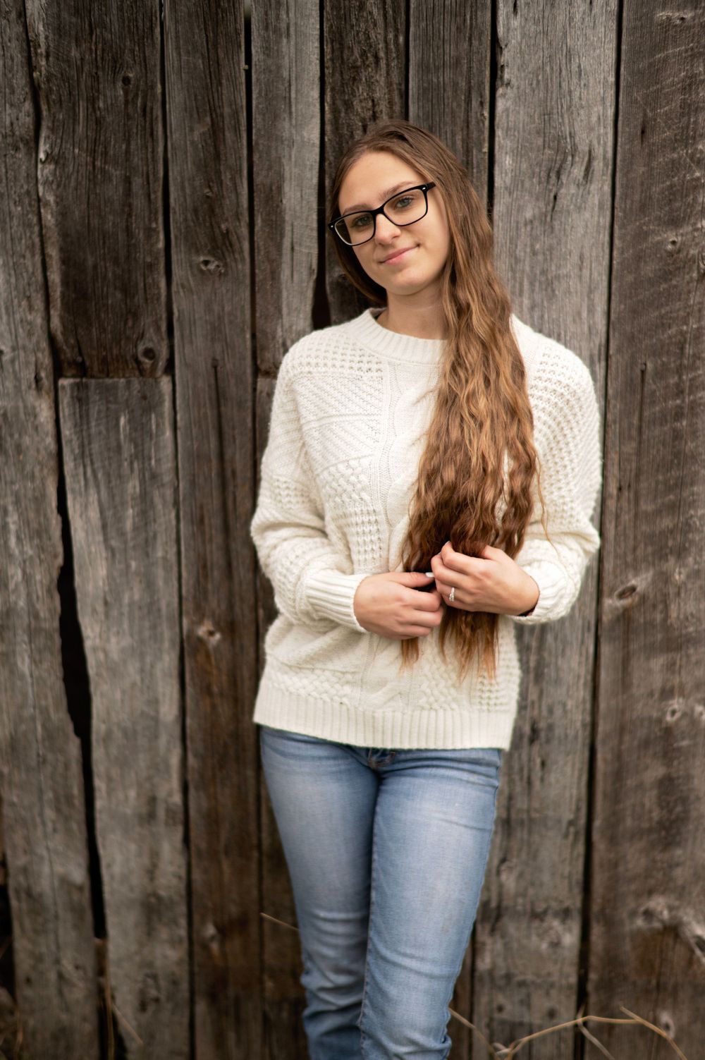 Senior in white sweater posing for senior session in Cook, Minnesota.