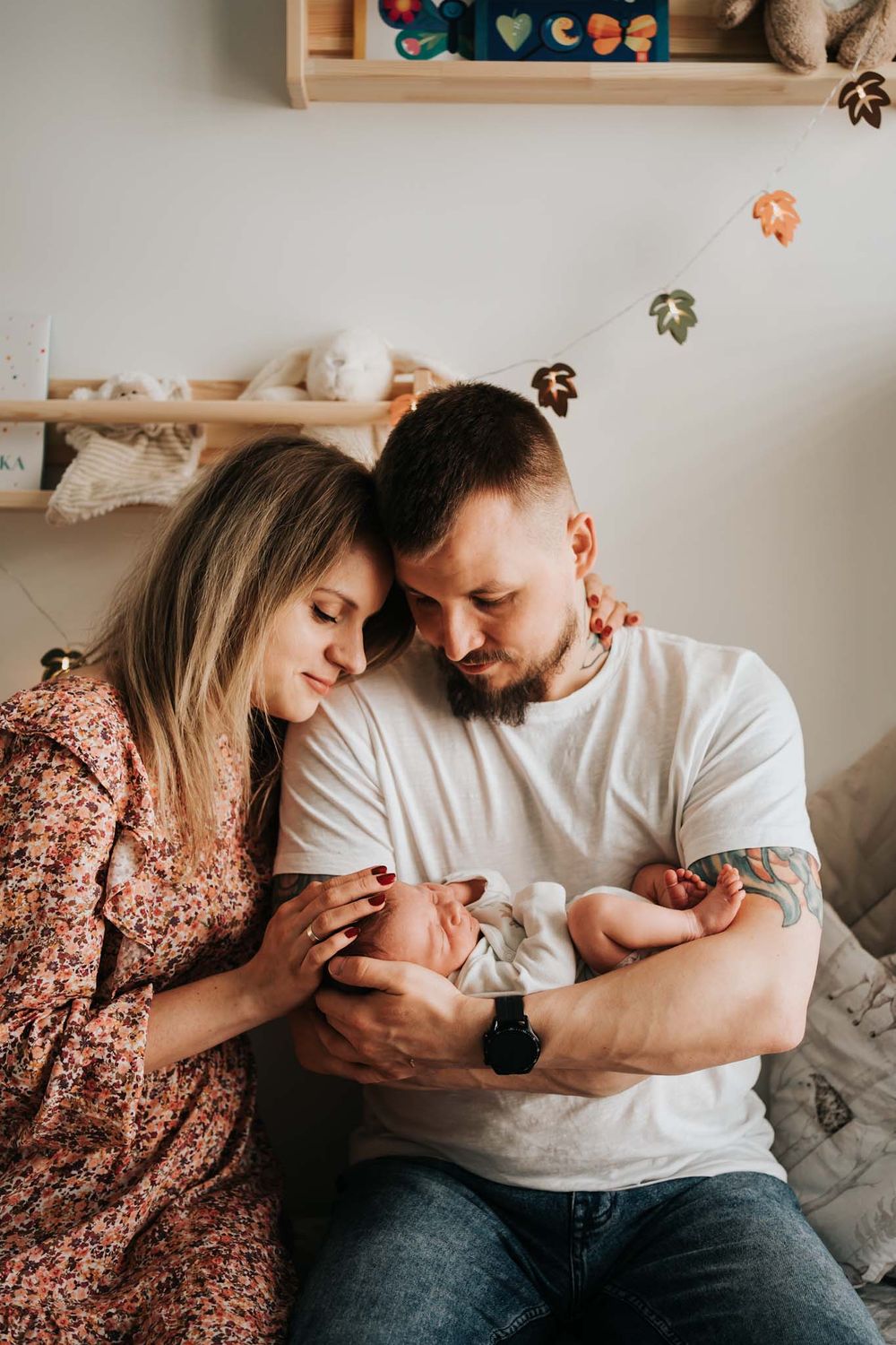 mama i tata trzymają noworodka - sesja domowa Kraków