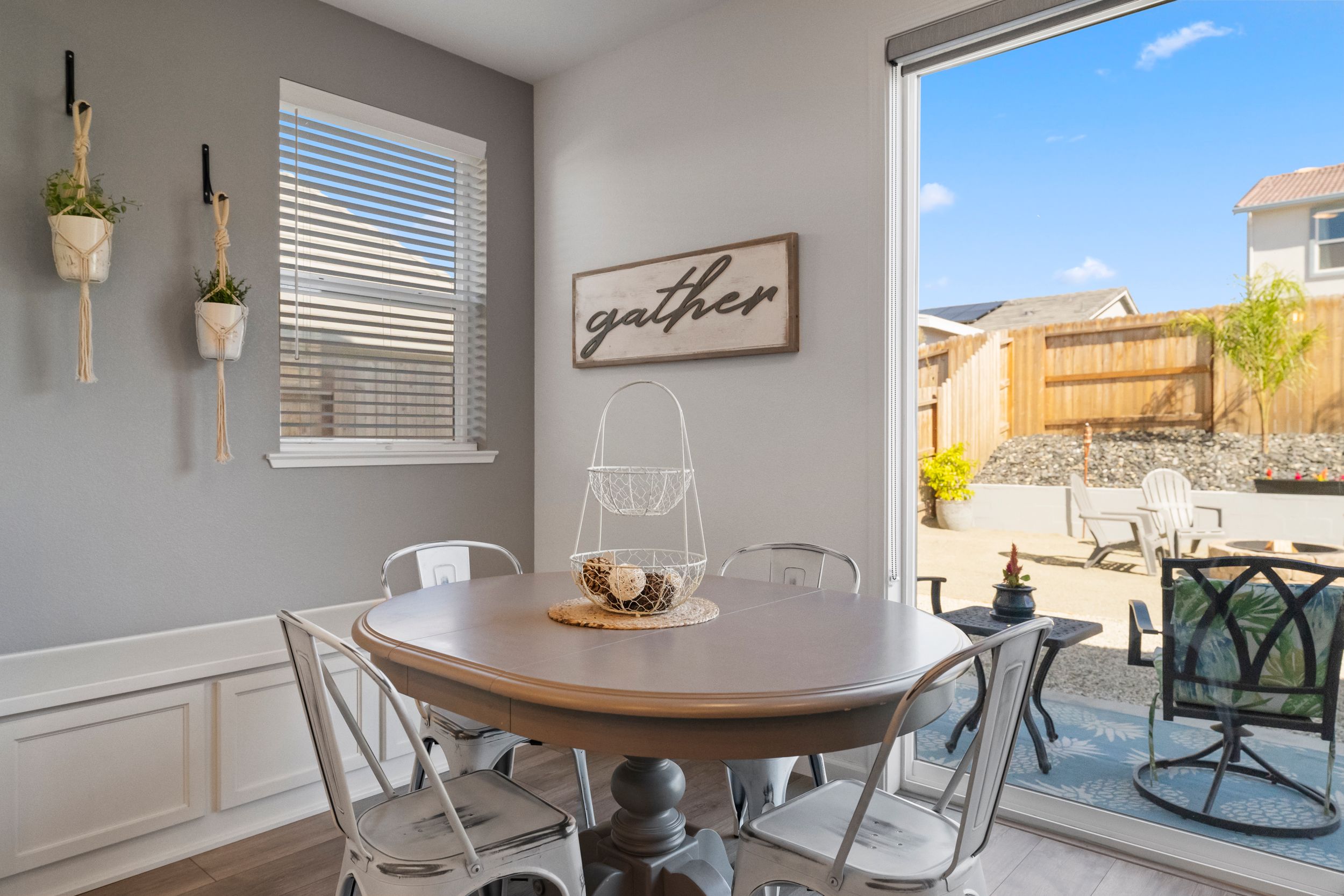 Contemporary dining area with natural lighting and modern furniture next to large windows.