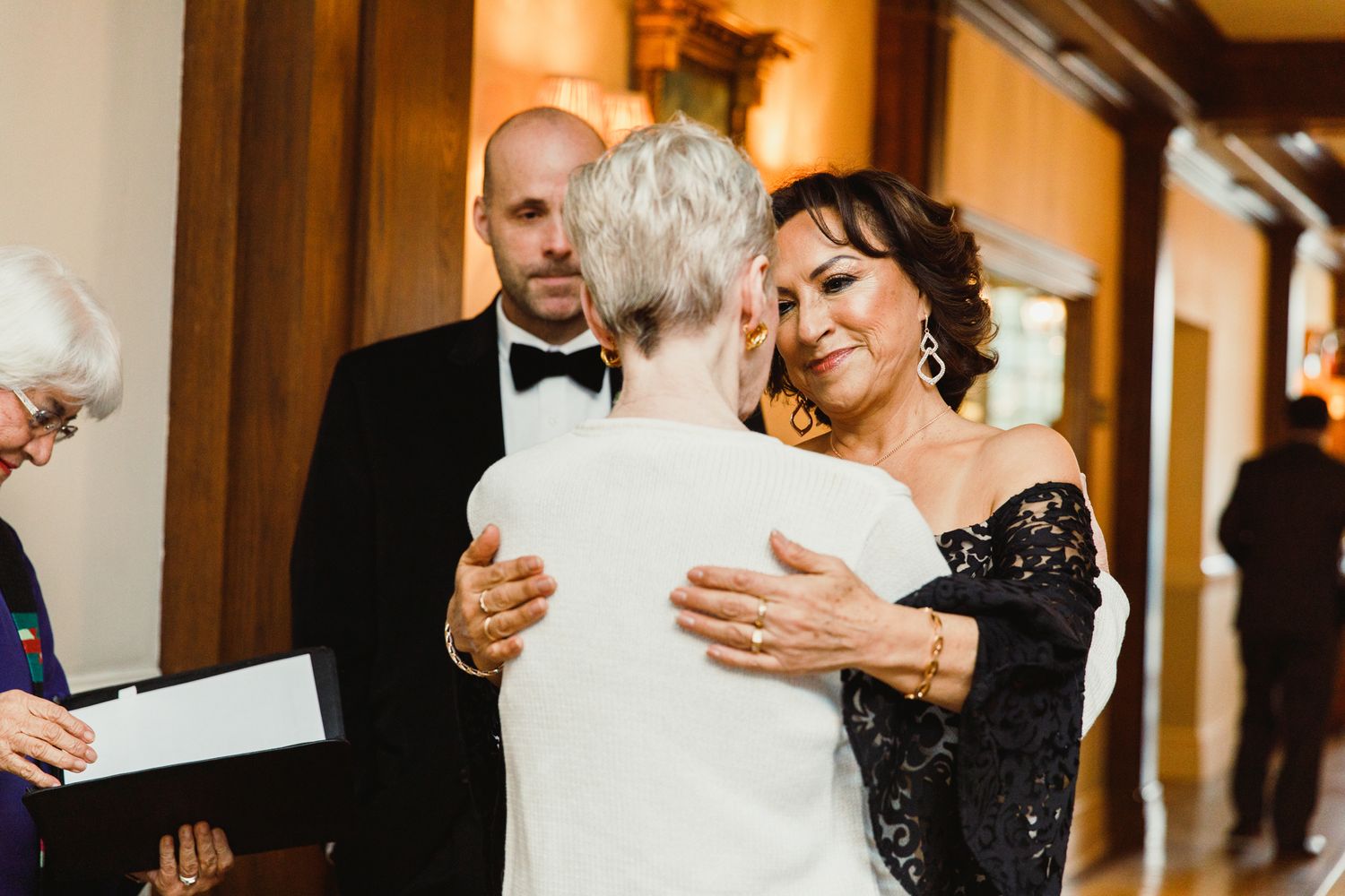 Guests embracing and sharing moments at a formal wedding celebration.
