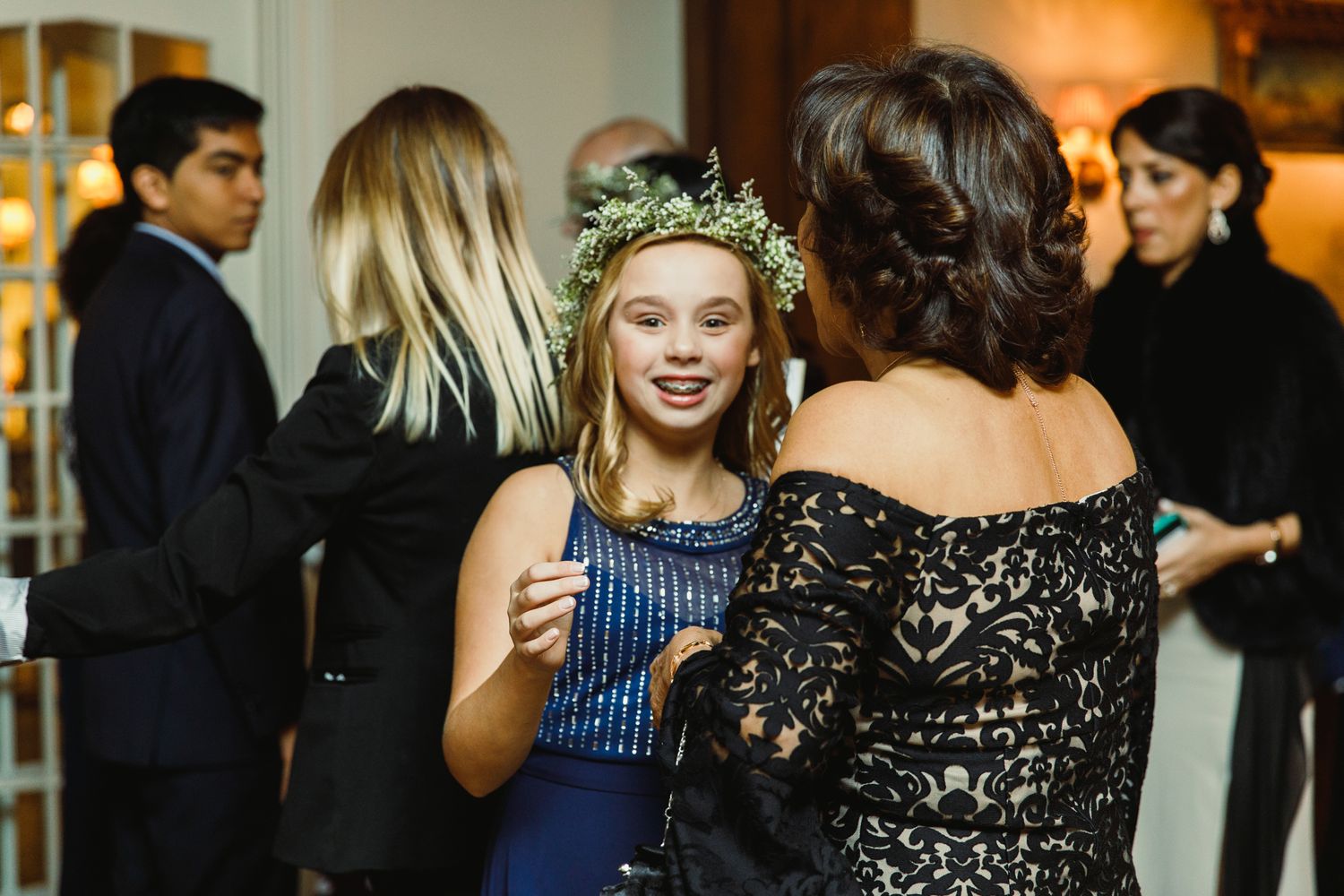 Wedding guests mingling at an evening reception in formal attire.