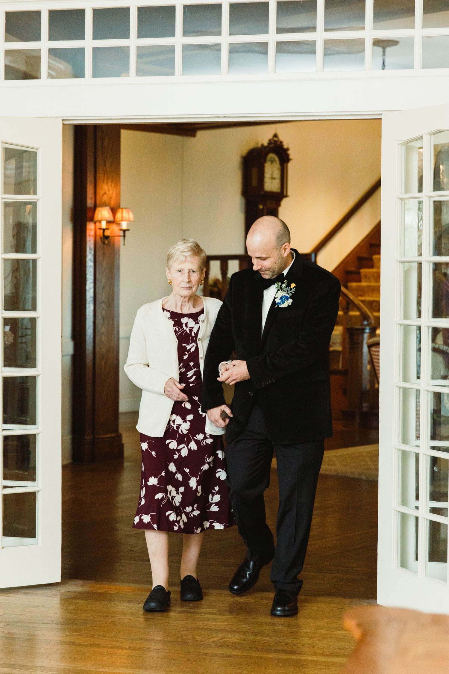 Formal event attendees dancing in an elegant room with white French doors.
