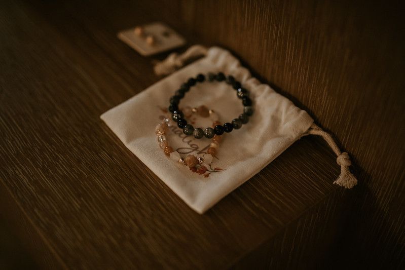Wedding accessories and jewelry artfully arranged on a dark wooden surface.