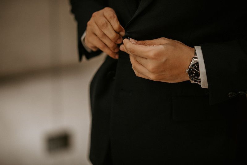 Dark silhouettes of hands gesturing against a black background.