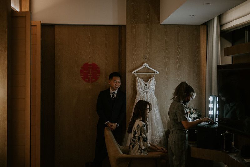 Interior hallway view with warm lighting and a white dress hanging on display.