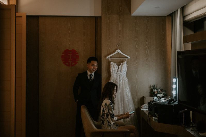 Hotel room interior with traditional Asian decor and a wedding dress displayed.