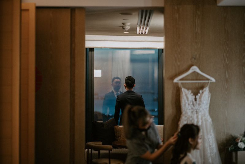 Modern hotel corridor with glass windows and a wedding dress visible.