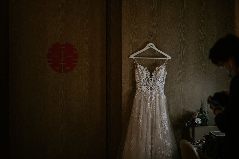 Wedding preparation room with traditional decor and white dress on display.