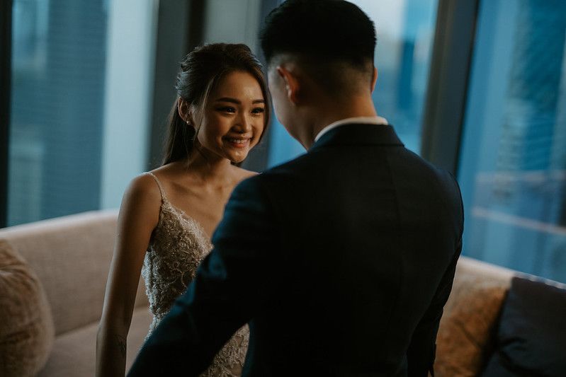 A couple shares an intimate moment in a high-rise room with city views.