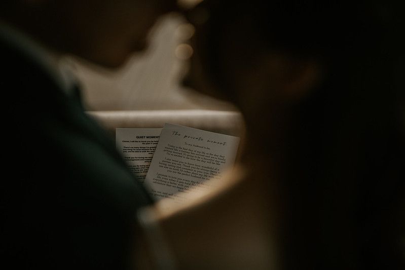 Wedding ceremony document being read in atmospheric lighting.