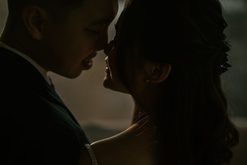 Silhouette of romantic couple in intimate moment against soft light.