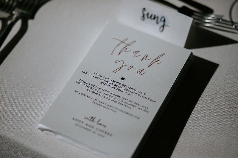 Artistic close-up of wedding stationery and paper goods in moody lighting.