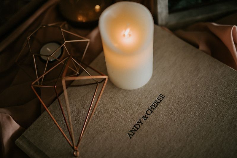 Geometric copper decorations and glowing candles create an intimate table setting atmosphere.
