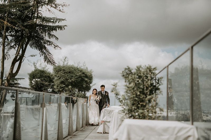 Overcast sky above a modern rooftop wedding venue with elegant white fabric decorations.