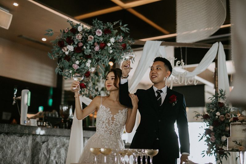 Elegant indoor wedding reception venue decorated with floral arrangements and soft lighting.