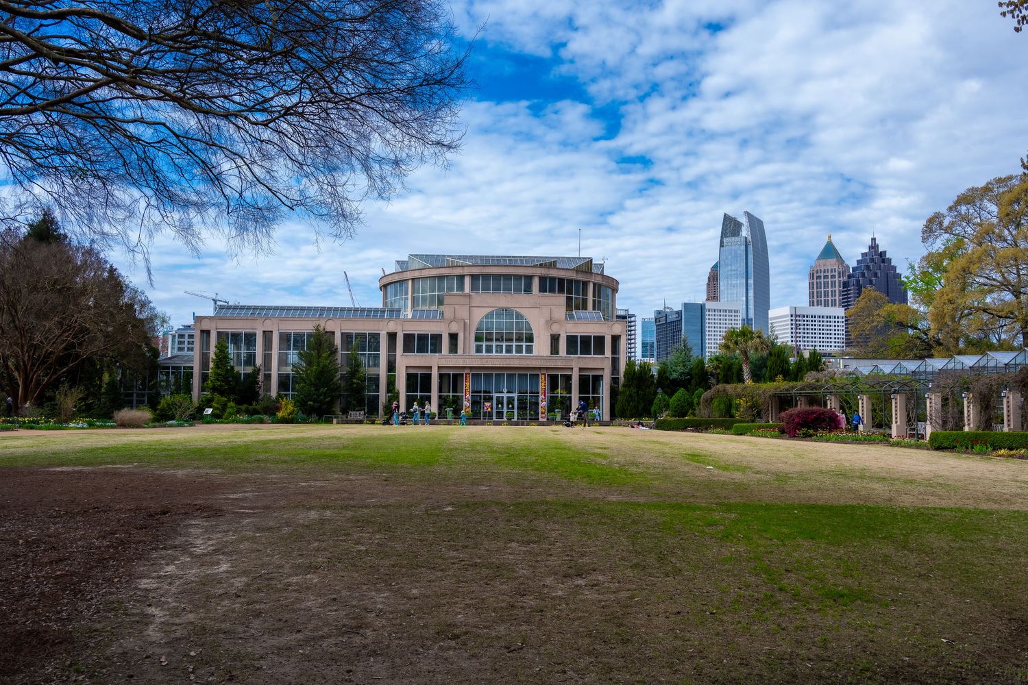 Classical style building with columns and Atlanta's downtown skyscrapers in the background.