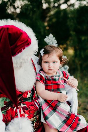 Holiday portrait featuring plaid dress and festive Christmas decor.