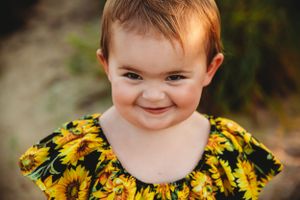 A bright and cheerful portrait featuring a yellow sunflower-printed dress.
