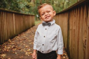 A dapper outfit with bow tie and button-up shirt on a wooden bridge walkway.