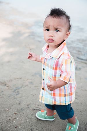 A close-up portrait at the beach featuring a plaid shirt and turquoise shoes.