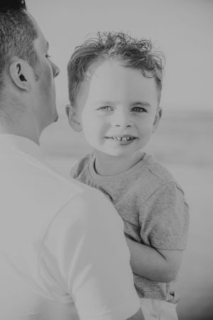 Black and white portrait showing intimate moment between parent and child.