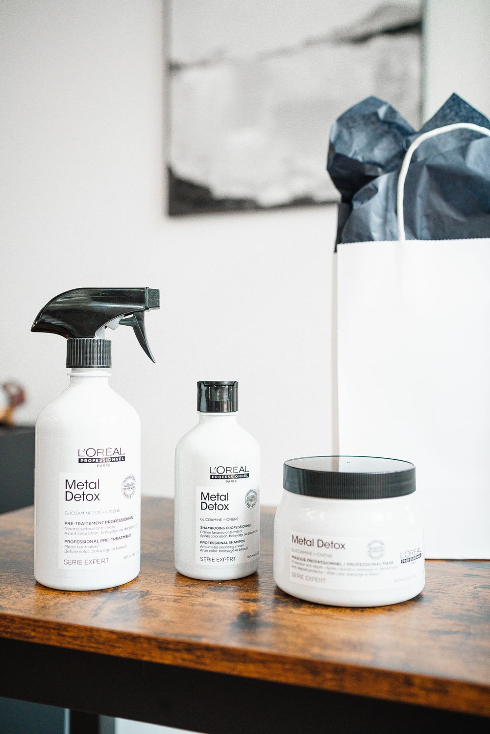 Professional L'Oreal hair care products displayed on wooden shelf.