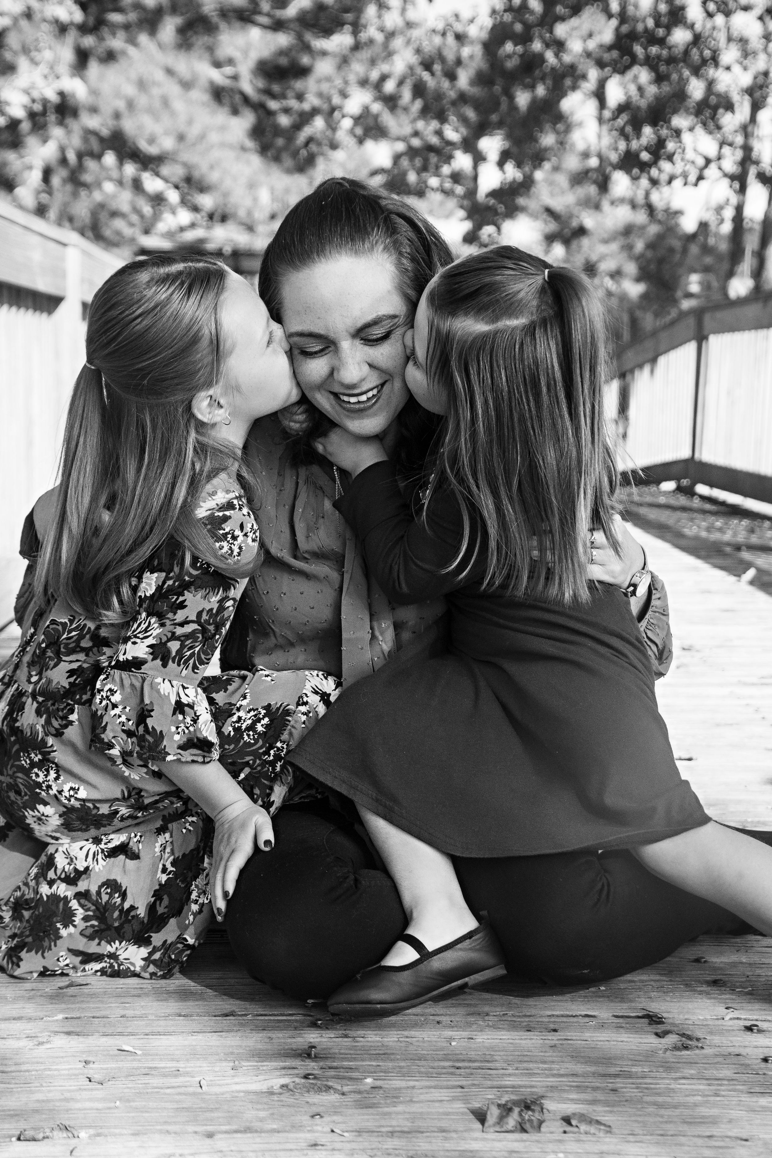 Series of black and white photos showing affectionate poses on a wooden deck.