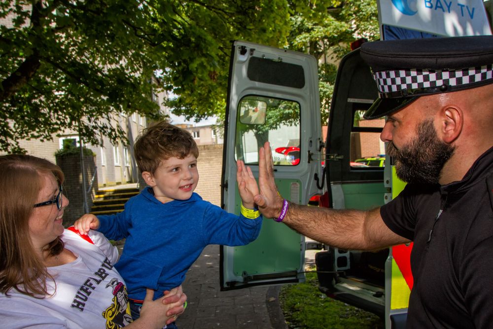 A group interacting near emergency vehicles in an outdoor setting.
