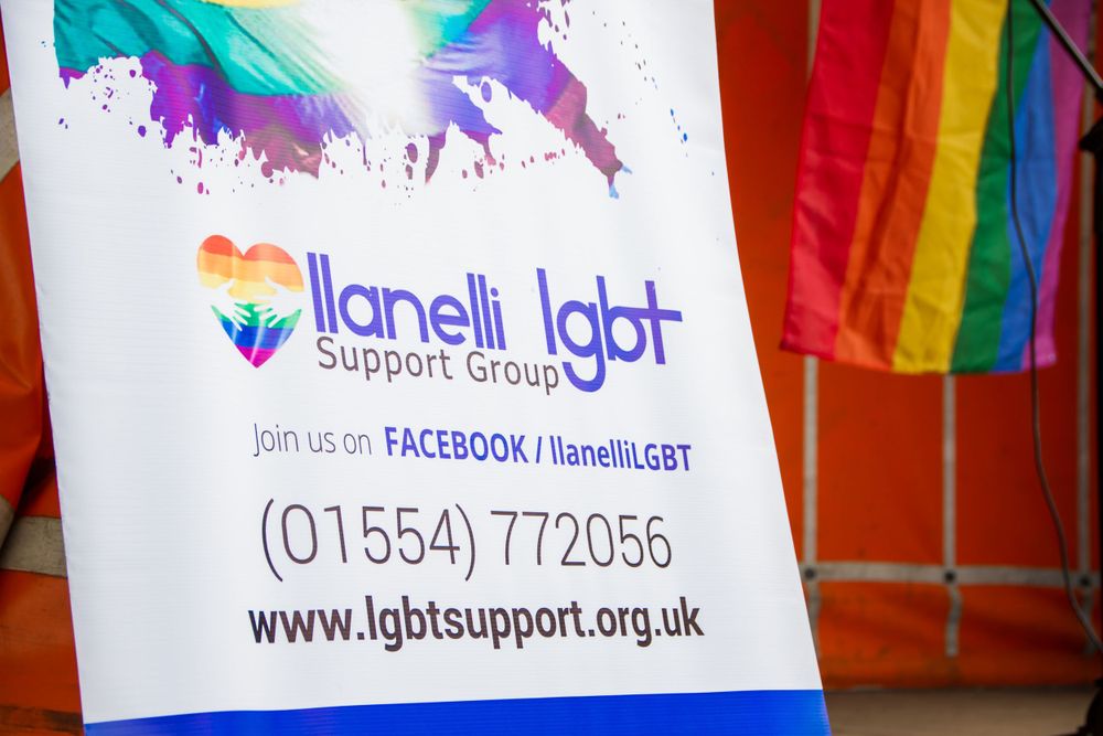 LGBT support group advertisement with rainbow colors and contact information.