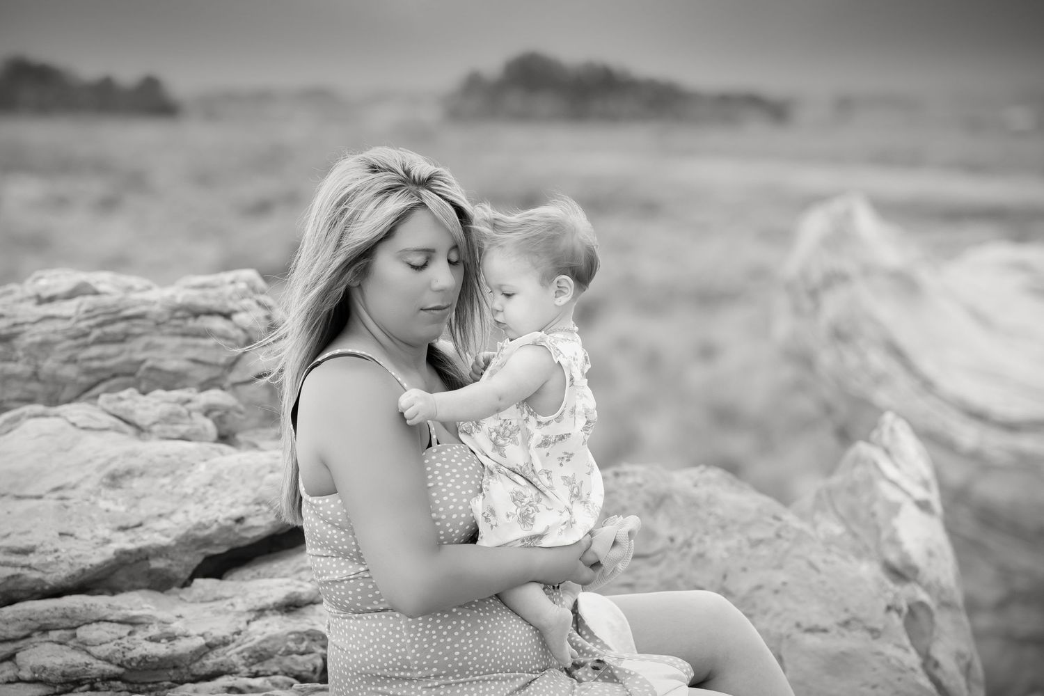 Black and white candid shots of tender family moments on desert rocks.
