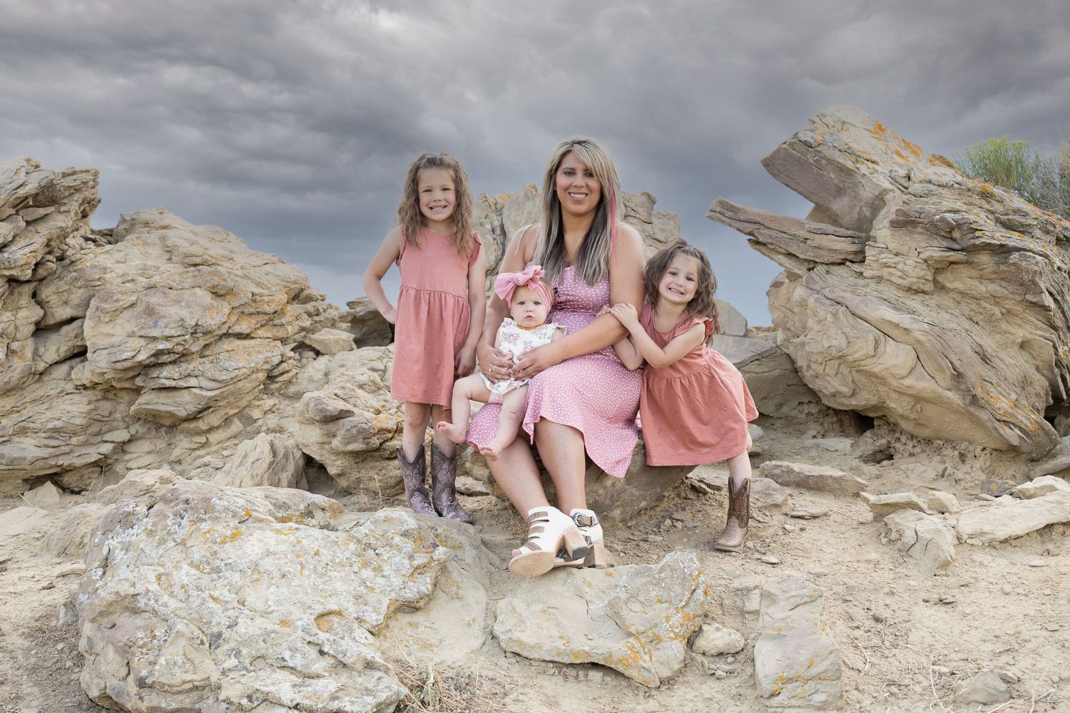 Group poses together on rocky desert terrain wearing matching pink.
