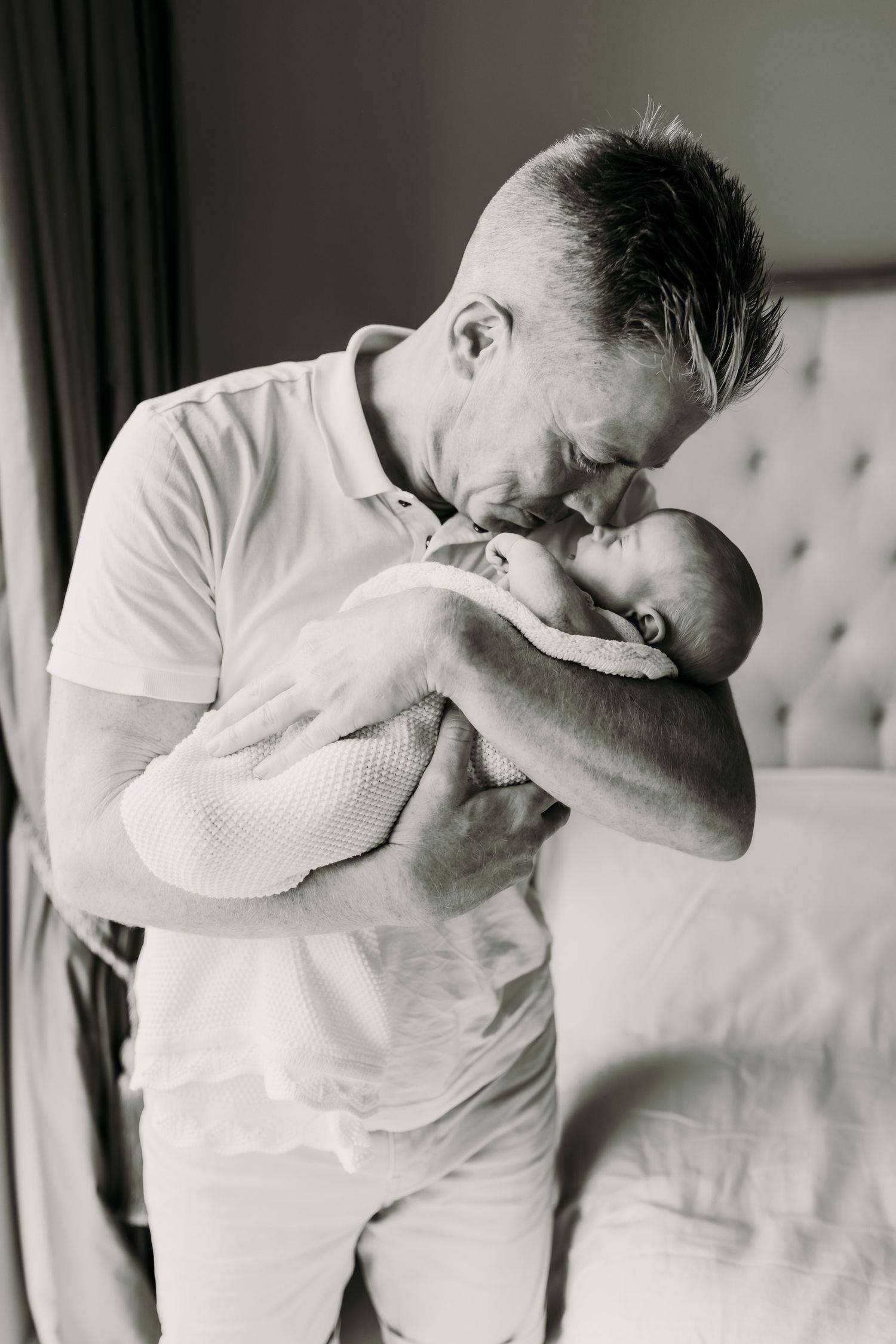 DAD CUDDLING NEWBORN BABY