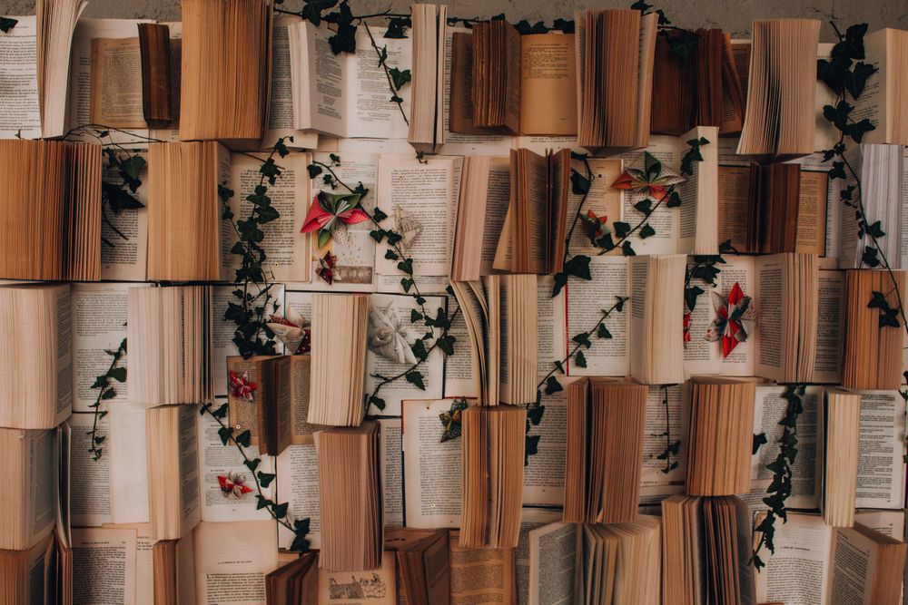 Decorative wall display made of open books with climbing ivy vines.